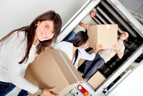 Movers carrying household furniture from a flat in Hammersmith